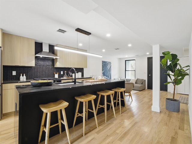 63 Jefferson Ave Unit 1, Jersey City, NJ 07307 - kitchen with wall chimney exhaust hood, modern cabinets, dark countertops, light brown cabinetry, and recessed lighting