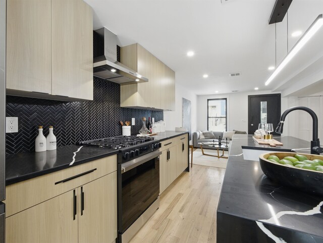 63 Jefferson Ave Unit 1, Jersey City, NJ 07307 - kitchen featuring range with gas stovetop, wall chimney range hood, dark countertops, light brown cabinets, and recessed lighting