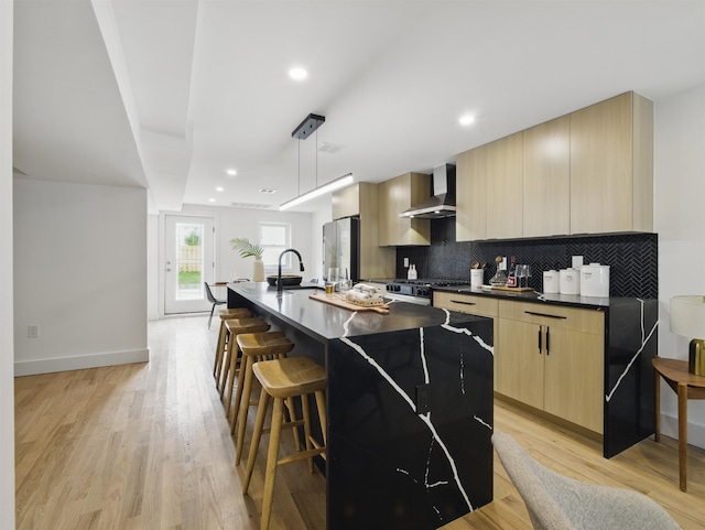 63 Jefferson Ave Unit 1, Jersey City, NJ 07307 - kitchen featuring wall chimney range hood, modern cabinets, freestanding refrigerator, light brown cabinetry, and dark countertops