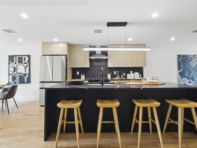 63 Jefferson Ave Unit 1, Jersey City, NJ 07307 - kitchen with freestanding refrigerator, modern cabinets, wall chimney exhaust hood, a kitchen breakfast bar, and tasteful backsplash
