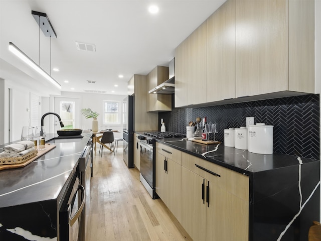 63 Jefferson Ave Unit 1, Jersey City, NJ 07307 - kitchen with stainless steel gas stove, modern cabinets, light brown cabinets, freestanding refrigerator, and decorative backsplash