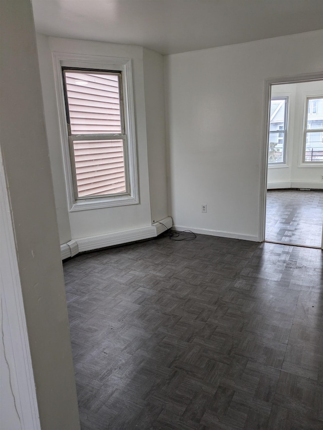 spare room with baseboards and a baseboard heating unit