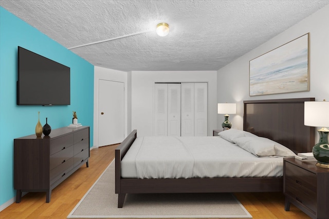 401 Harmon Cv, Secaucus, NJ 07094 - bedroom with light wood-style floors, a closet, and a textured ceiling