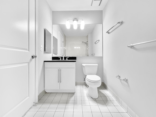 bathroom with toilet, vanity, tile patterned flooring, and tiled shower