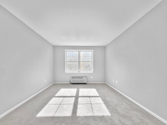 carpeted spare room with an AC wall unit