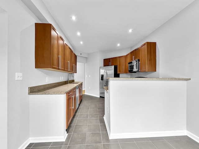 kitchen featuring light stone countertops, tile patterned flooring, and appliances with stainless steel finishes