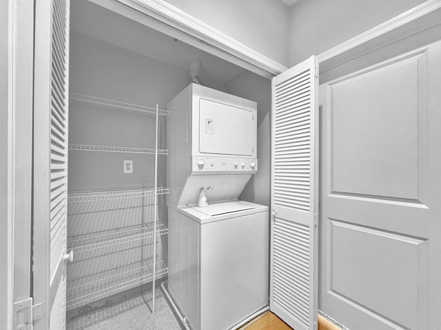 washroom featuring stacked washer and clothes dryer