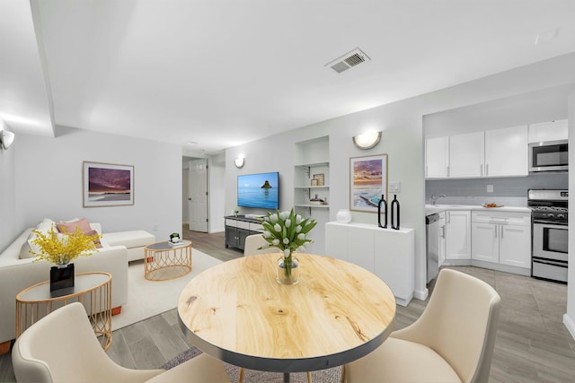 1228 Park Ave Unit B, Hoboken, NJ 07030 - dining space with built in shelves and light wood-style floors