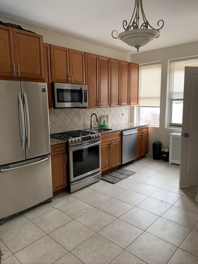 5843 Kennedy Blvd, North Bergen, NJ 07047 - kitchen with appliances with stainless steel finishes, a sink, brown cabinets, decorative backsplash, and light tile patterned flooring
