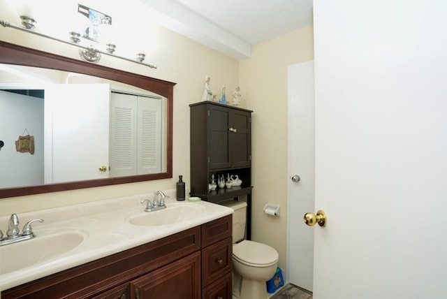 bathroom with vanity, a textured ceiling, and toilet