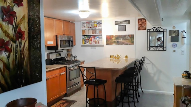 1215 Bergenline Ave, Union City, NJ 07087 - kitchen with stainless steel appliances, a kitchen bar, a peninsula, light countertops, and baseboards
