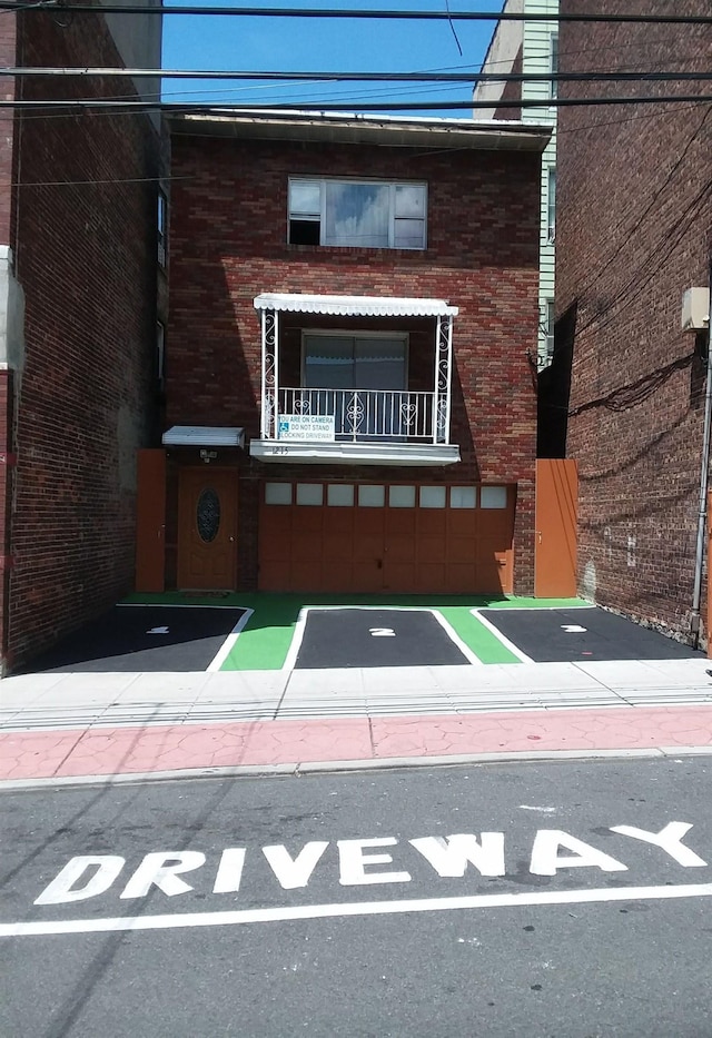 1215 Bergenline Ave, Union City, NJ 07087 - view of front of house with uncovered parking, brick siding, and a balcony