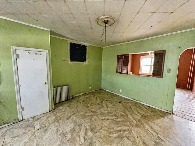 spare room featuring radiator heating unit and ornamental molding