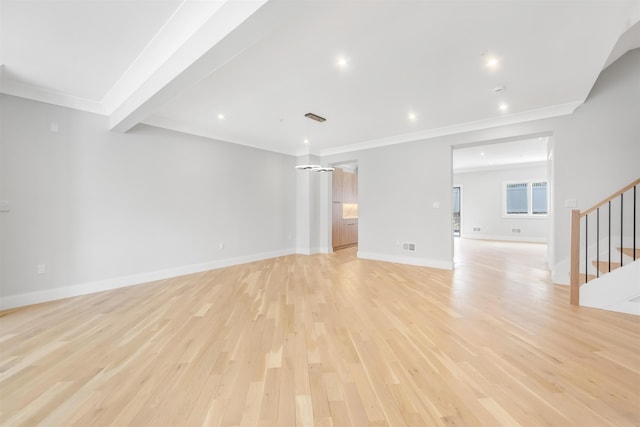 unfurnished living room featuring ornamental molding, light wood-style flooring, baseboards, and stairs