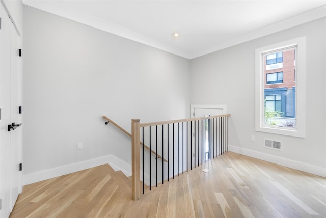 interior space featuring visible vents, crown molding, baseboards, and wood finished floors