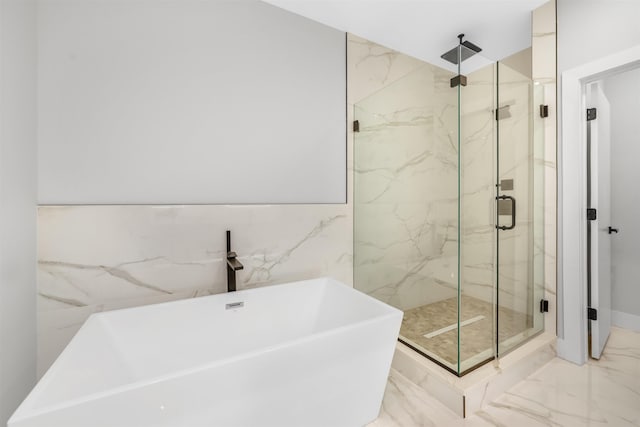 full bathroom featuring marble finish floor, a freestanding tub, and a marble finish shower