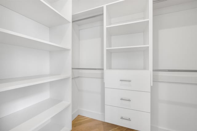 walk in closet with wood finished floors