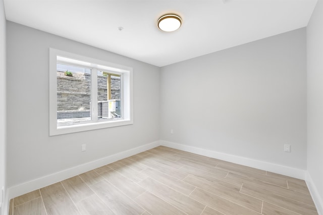 empty room featuring wood finish floors and baseboards