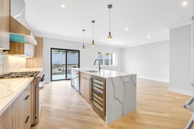 kitchen with an island with sink, beverage cooler, light stone counters, and a sink