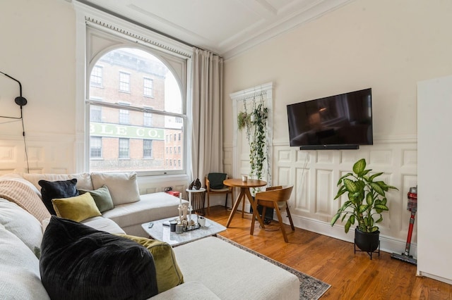 living room with wood-type flooring and ornamental molding