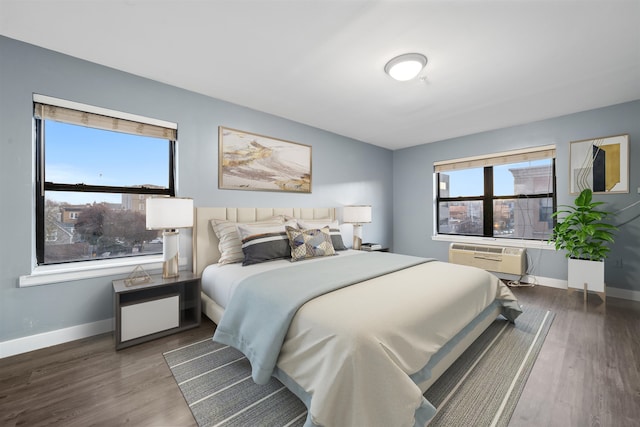 bedroom featuring an AC wall unit and dark wood-type flooring