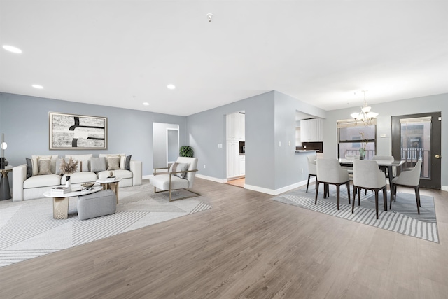 living room with light hardwood / wood-style floors and an inviting chandelier