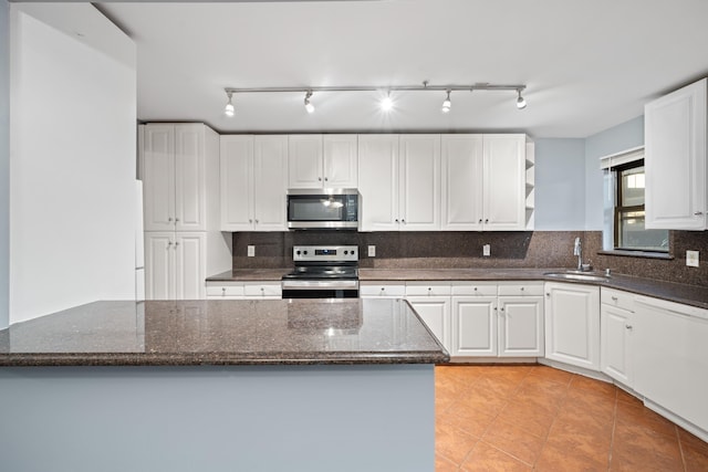 kitchen featuring white cabinets, dark stone countertops, sink, and stainless steel appliances