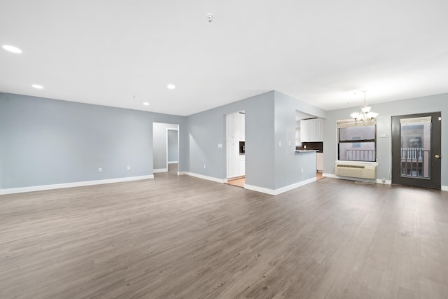 unfurnished living room featuring hardwood / wood-style flooring and an inviting chandelier