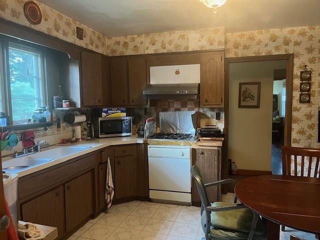 18 Messler St, East Brunswick, NJ 08816 - kitchen with wallpapered walls, appliances with stainless steel finishes, under cabinet range hood, light countertops, and light flooring