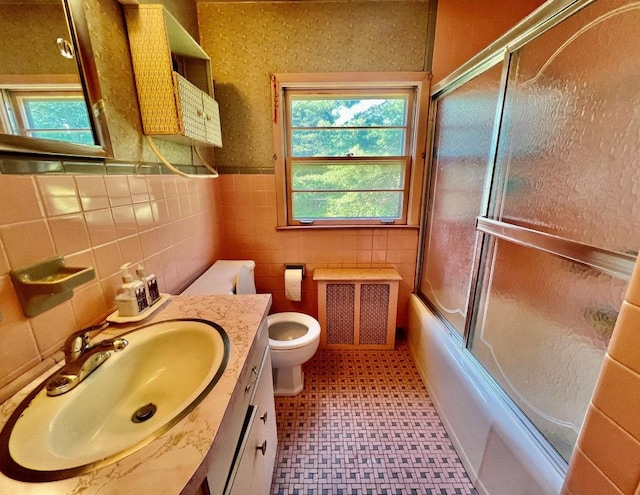 18 Messler St, East Brunswick, NJ 08816 - full bathroom with vanity, radiator heating unit, combined bath / shower with glass door, a wainscoted wall, and tile walls