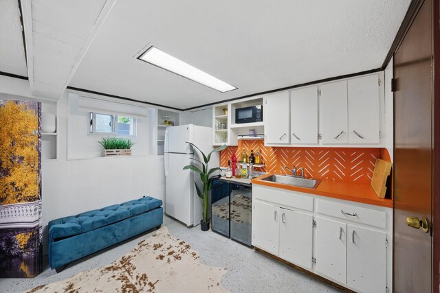 152 W 30th St, Bayonne, NJ 07002 - kitchen featuring freestanding refrigerator, a sink, built in microwave, white cabinets, and backsplash