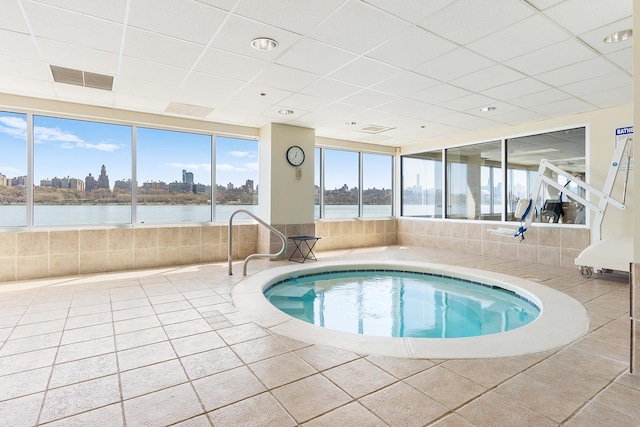 view of pool featuring an indoor in ground hot tub and a water view
