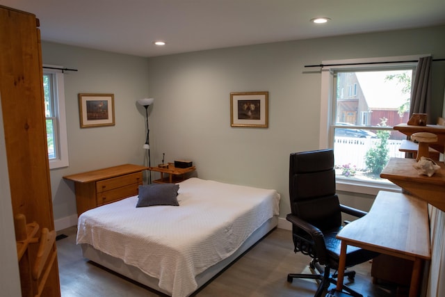 bedroom with multiple windows, wood finished floors, and recessed lighting