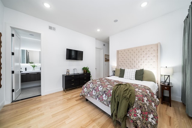 bedroom featuring light hardwood / wood-style floors and ensuite bathroom