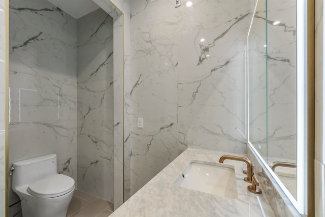 bathroom with tile walls, vanity, and toilet