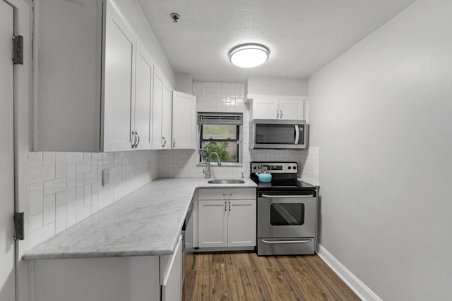 11 Cuneo Pl Unit D, Jersey City, NJ 07307 - kitchen featuring stainless steel appliances, a sink, dark wood-type flooring, white cabinets, and a textured ceiling