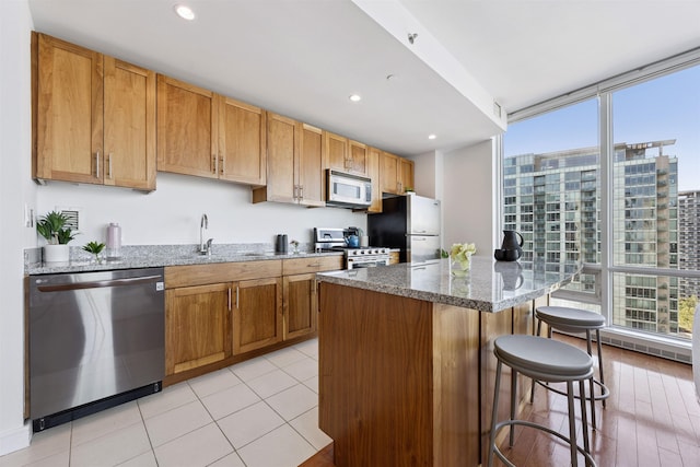 20 Newport Pkwy Unit 2008, Jersey City, NJ 07310 - kitchen with stainless steel appliances, a breakfast bar, stone countertops, a wall of windows, and a kitchen island