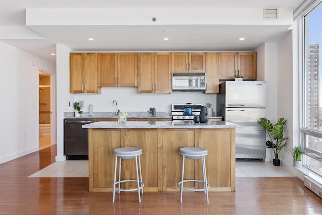 20 Newport Pkwy Unit 2008, Jersey City, NJ 07310 - kitchen featuring appliances with stainless steel finishes, light wood finished floors, a kitchen island, light stone counters, and recessed lighting