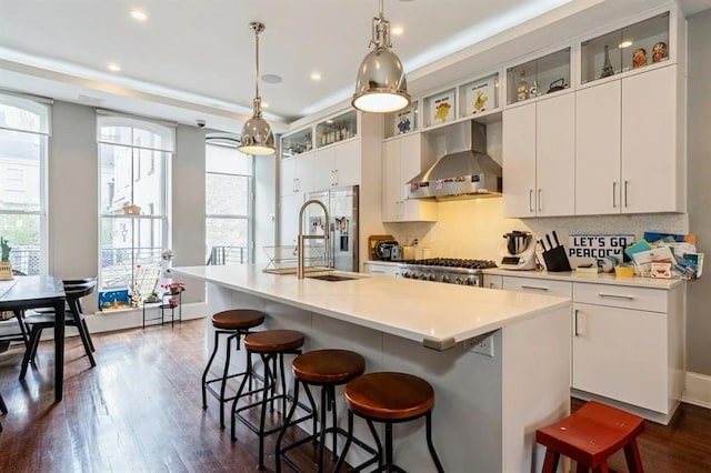 225 8th St, Jersey City, NJ 07302 - kitchen featuring wall chimney exhaust hood, healthy amount of natural light, an island with sink, a breakfast bar, and recessed lighting