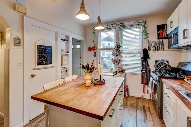 8212 2nd Ave, North Bergen, NJ 07047 - kitchen featuring wooden counters, stainless steel appliances, white cabinetry, light wood-type flooring, and a kitchen island