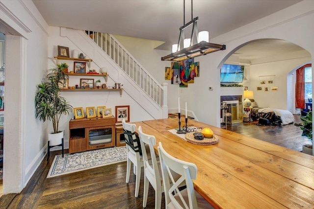 8212 2nd Ave, North Bergen, NJ 07047 - dining area with dark wood-style flooring, arched walkways, and stairway