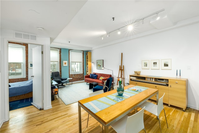 dining room with rail lighting and light wood finished floors