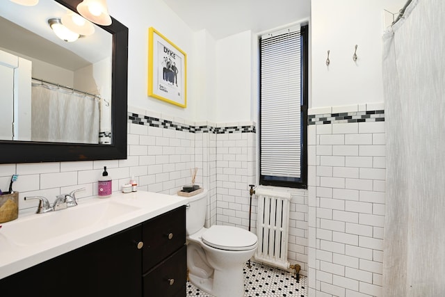 bathroom featuring toilet, tile walls, radiator heating unit, vanity, and tile patterned flooring