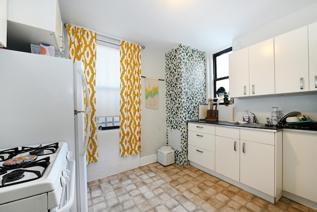 kitchen with white cabinetry, sink, and white appliances