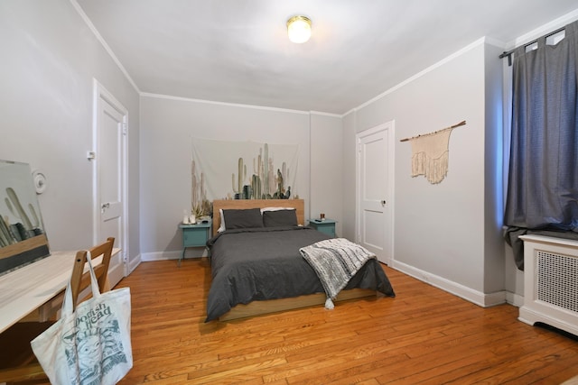 bedroom featuring ornamental molding and light wood-type flooring