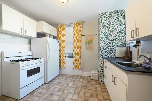 kitchen with white cabinetry, sink, and white appliances