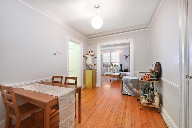 dining space featuring ornamental molding and light hardwood / wood-style floors