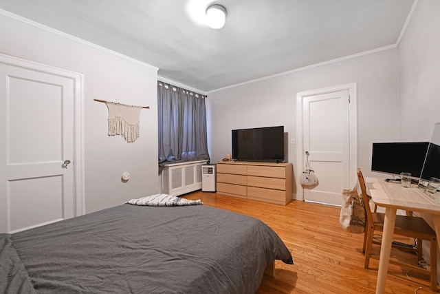 bedroom with radiator, hardwood / wood-style flooring, and ornamental molding