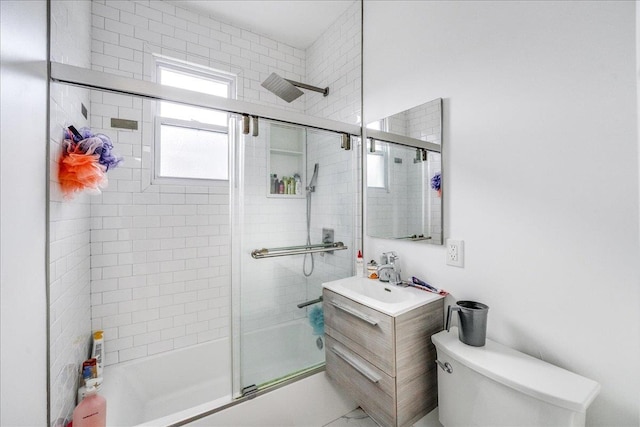 full bathroom with combined bath / shower with glass door, vanity, and toilet