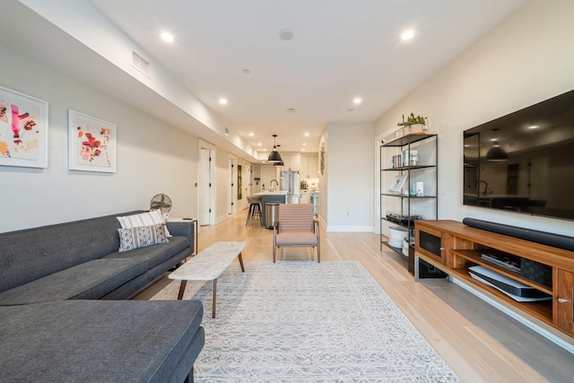 living room with sink and light hardwood / wood-style floors